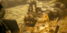 a blurred image of a pile of gold leaves and a statue