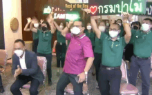 a group of people wearing face masks are dancing in front of a sign that says rest of the best i am the best