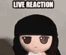 a stuffed doll with long black hair and the words `` live reaction '' behind it .