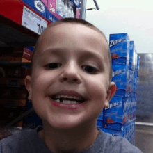 a young boy in front of a stack of ziploc bags