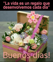 a box of flowers with a pink ribbon and the words buenos dias