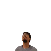 a man with glasses looks up at a green cross above his head