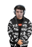 a man wearing headphones and a black jacket that says supreme