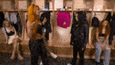 a group of women standing in a locker room with a sign that says ' candy bar ' on it