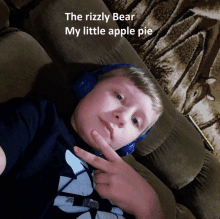 a young boy wearing headphones laying on a couch with the words the rizzly bear my little apple pie