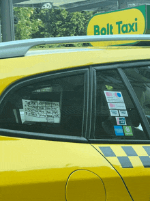 a yellow car with a sign that says bolt taxi on it