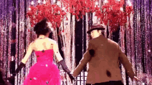 a woman in a pink dress is dancing with a man in a brown jacket