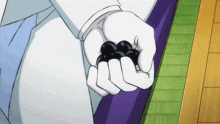 a person in white gloves holds a bunch of black balls in their hands