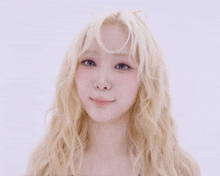 a woman with blonde hair is smiling and making a face
