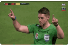 a soccer referee is making a gesture with his hands while wearing a mcdonald 's logo on his shirt .