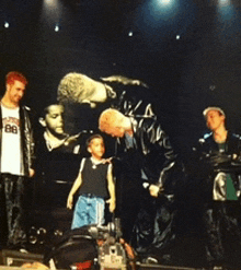 a group of people on a stage with a man wearing a shirt that says bb