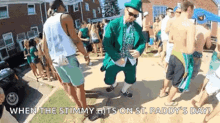 a man in a leprechaun costume is dancing in front of a crowd of people on st. paddy 's day .