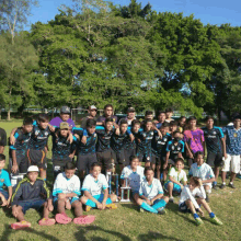 a group of soccer players posing for a photo with a trophy in the middle