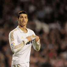 a soccer player wearing a white shirt with gold stripes and the word bwin on the sleeve