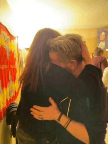 a man and woman hugging in front of a curtain that says futura milano