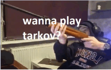 a person holding a gun with the words " wanna play tarkov " written above them