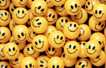 a bunch of yellow smiley faces are lined up in a pile