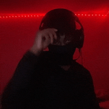 a man wearing headphones and a mask looks at the camera