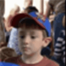 a blurry picture of a young boy wearing a red baseball cap