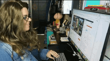 a woman is typing on a keyboard in front of a computer screen that says ' gmail ' on it