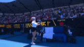 a woman is holding a tennis racquet in front of a sign that says lions