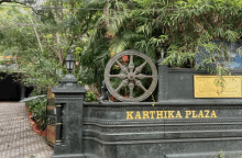 a sign for karthika plaza with a wheel on top