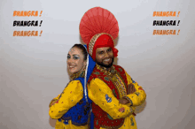 a man and a woman are posing for a photo with the words bhangra written on the wall behind them