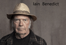 a man wearing a straw hat with the name lain benedict written above him