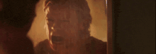 a man is standing in front of a mirror looking at his reflection .