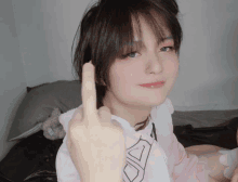 a girl giving the middle finger while wearing a pink dress