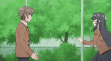 a boy and a girl are standing next to each other in a field .