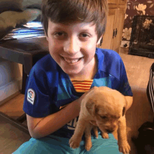 a boy holding a puppy wearing a laliga jersey