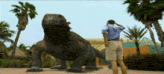 a man stands in front of a large lizard statue
