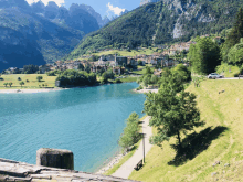 a lake with mountains in the background and a small town on the shore