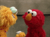 two sesame street stuffed animals elmo and fozzie are looking at each other