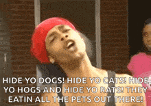 a woman wearing a red hat and a black tank top is saying hide yo dogs ! hide yo cats !