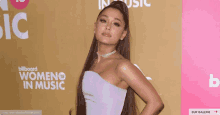 a woman in a purple dress stands in front of a billboard that says women in music