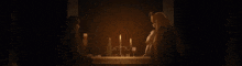 a man and a woman are sitting at a table with candles .