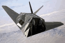 a stealth fighter jet is flying through the air over a desert .