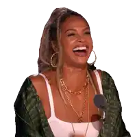 a woman is laughing in front of a microphone while wearing a green jacket
