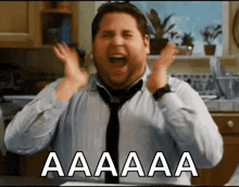 a man in a tie is screaming in a kitchen with the word aaa written on the bottom