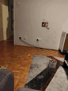 a living room with a box of toys on the floor and a picture of a dog on the wall