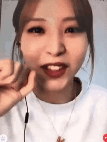 a close up of a woman 's face with a necklace and earphones on .