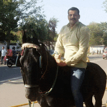 a man in a yellow shirt rides a black horse