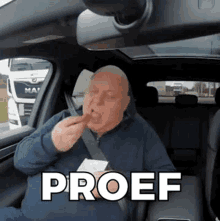 an older man is sitting in the back seat of a car eating a french fry .