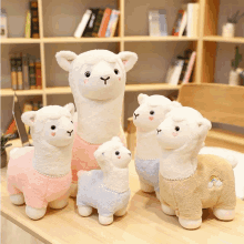 a group of stuffed llamas sitting on a wooden table