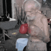 an old man with a beard is wearing boxing gloves in a room