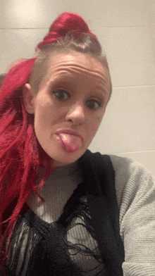 a woman with red hair sticks out her tongue