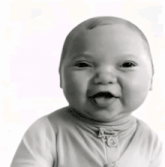 a black and white photo of a baby smiling