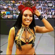 a female wrestler wearing a crown is smiling in front of a screen that says diva live